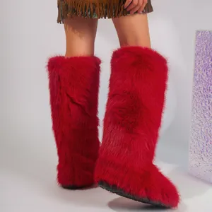 Detailed macro texture of bright red Y2K fluffy faux fur knee-high snow boots for women
