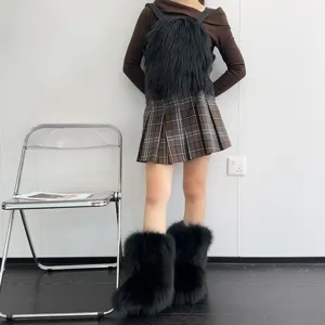 Detailansicht der flauschigen schwarzen Kunstpelz-Y2K-Schneestiefel mit Karo-Faltenrock