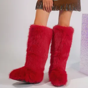 Detailed close-up view of bright red faux fur knee-high boots with thick fluffy texture