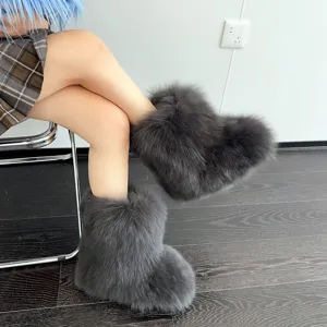 Nahaufnahme von stylischen grauen, flauschigen Y2K-Schneestiefeln mit dicker Sohle
