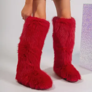 Close-up detail of vibrant red faux fox fur Y2K style knee-high snow boots