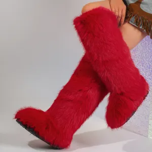 Detailed macro view of vibrant red faux fur knee-high snow boots in trendy Y2K aesthetic