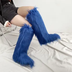 Detailed view of vibrant blue shaggy faux fur knee-high snow boots worn by a fashion model