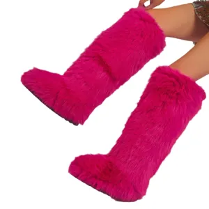 Vibrant fuchsia faux fur knee-high boots in Y2K style shown on model against white backdrop.