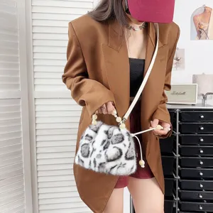 Schicke Leopard-Eimer-Tasche aus Nerzimitat mit Perlengriff, getragen von einem Model