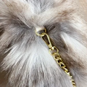 Detalle macro de un lujoso bolso de piel sintética con elegante cadena de metal dorado