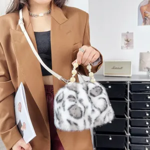 Schicke Retro-Beuteltasche aus Leoparden-Kunstfell mit edlem Perlengriff und langem Gurt