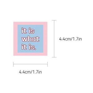 Detailopname van een vierkante decoratieve sticker met roze-blauwe rand en tekstontwerp.