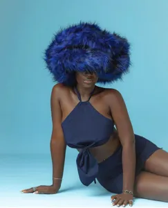 Gros plan sur un chapeau bleu luxueux en fausse fourrure et un haut dos nu bleu marine