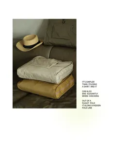 Pila di borse da viaggio piegate beige e senape su un divano in pelle marrone elegante e comodo