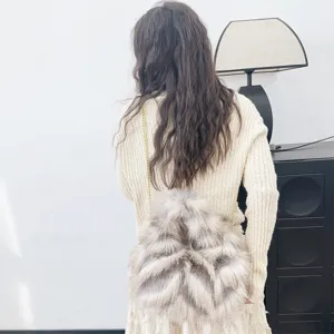 Vista trasera de una modelo con bolso bandolera de pelo sintético y cadena de oro