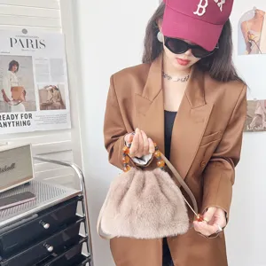 Detailansicht einer schicken Retro-Kunstfell-Handtasche mit bernsteinfarbenem Perlengriff