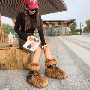 Detailed view of Y2K brown faux fur platform boots with black studded straps outdoors
