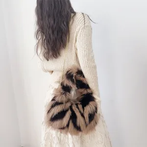 Detalle de bolso bandolera de piel sintética con estampado animal y cadena dorada elegante