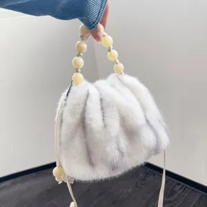 Detailansicht einer luxuriösen weichen weißen Kunstpelz-Tasche mit Perlengriff