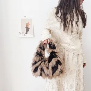 Bolso de mano de piel sintética de zorro con estampado de galones, llevado por modelo.
