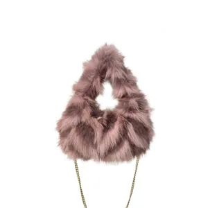 Detalle de bolso de lujo en piel sintética malva con elegante correa de cadena dorada