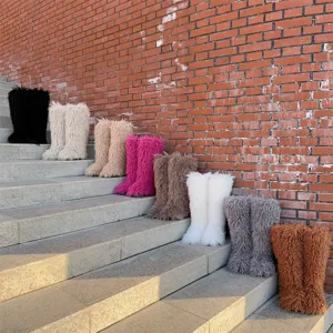 Kleurrijke kniehoge sneeuwlaarzen van imitatiebont op een stenen buitentrap getoond