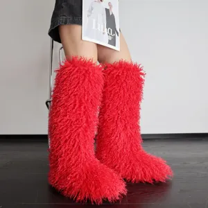 Zijaanzicht van felrode pluizige sneeuwlaarzen van imitatiebont voor dames in de winter