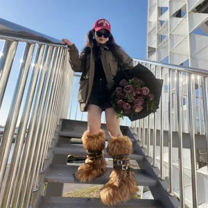Trendy brown Y2K faux fur boots with black rivet buckles shown on metal stairs outdoor