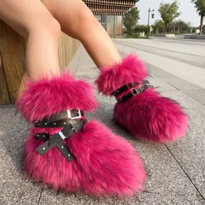 Detail shot of bright pink furry snow boots featuring punk rivets and black straps
