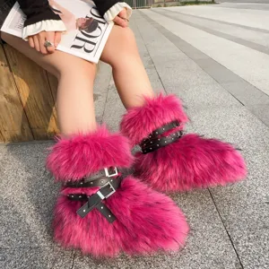 Detail of hot pink faux fur boots featuring black leather buckled straps and silver studs