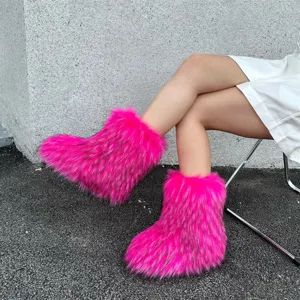 Detail shot showing vibrant pink faux fur snow boots in Y2K style worn with a skirt.