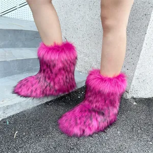 Close-up detail of fluffy pink faux fur snow boots with black spots in trendy Y2K style