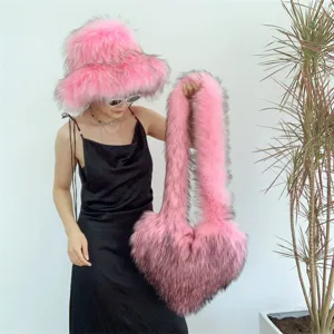 Chapeau cloche en fausse fourrure rose et sac à main assorti porté par un modèle