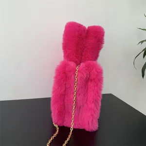 Detalle de un mini bolso tote de piel sintética rosa con orejas de conejo y cadena dorada