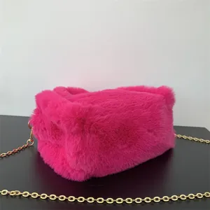 Vista detallada de la suave textura de piel sintética rosa de un mini bolso con cadena