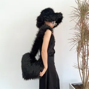 Modèle portant un ensemble chapeau en fausse fourrure noire et sac coeur duveteux assorti.