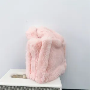 Primer plano de un mini bolso tote de piel sintética rosa suave sobre un altavoz blanco