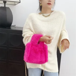 Primer plano de mini bolso tote de piel sintética rosa con elegante cadena dorada.