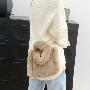 Vista detallada del mini bolso tote de piel sintética marrón llevado por una modelo
