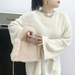 Primer plano de un mini bolso tote de peluche beige de piel de conejo sintética.