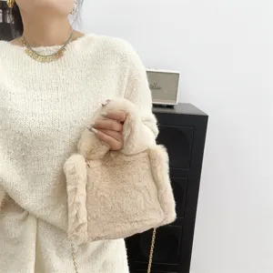 Primer plano de un mini bolso tote beige de piel sintética con cadena de oro