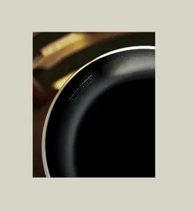 Dettaglio macro del bordo nero opaco di un cestino moderno con testo in rilievo