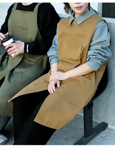 Vista dettagliata dei grembiuli da barista color cammello e verde oliva con grandi tasche