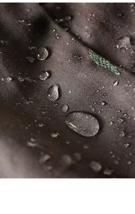 Macro view showing the waterproof fabric surface with clear water droplets on it.