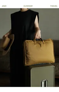 Grande borsa da viaggio kaki fissata al manico di una valigia per viaggiare comodi