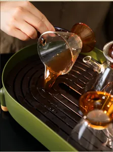 Primo piano del tè versato in un moderno vassoio di drenaggio verde dal design contrastante