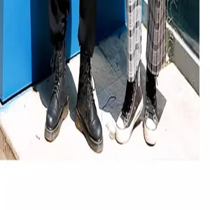 Vista detallada del personal con botas de cuero negras y zapatillas de deporte altas
