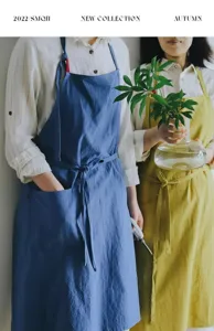 Scatto lifestyle di due modelle che indossano grembiuli da cucina in cotone blu e giallo.