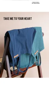 Primo piano di grembiuli in cotone giapponese blu navy e verde acqua su una sedia in legno