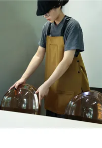 Grembiule da lavoro marrone indossato da modella in un caffè minimalista