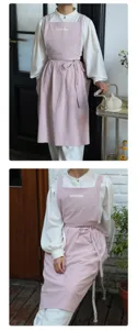Dettaglio di un grembiule in cotone rosa minimalista con laccio in vita e tasche laterali.