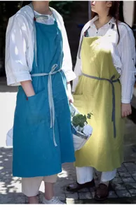 Due donne che indossano eleganti grembiuli giapponesi in cotone e lino blu e giallo