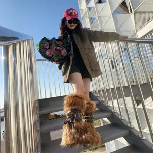 Y2K punk style faux fur boots with platform and buckled leather straps shown outdoors