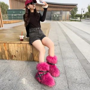 Y2K fuchsia faux fur snow boots with black buckle straps worn in outdoor street setting